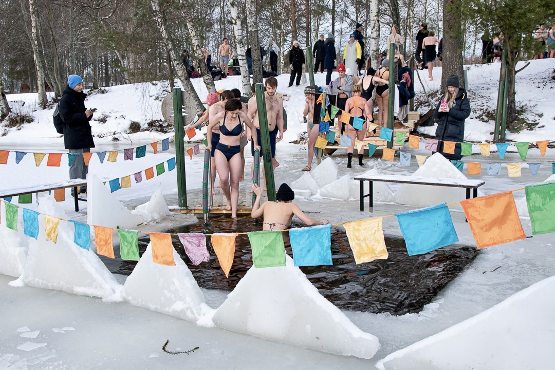 Söndagsdopp vid vaken, vimplar över isen och badare på väg ner